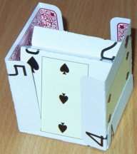 The fifth card is placed to the left of the first card, inside the flap of this first card but with its own flaps to the outside of the second and third cards